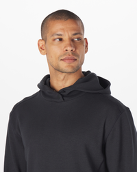 Black hoodie with drawstring, shown on a model wearing it against a white background.
