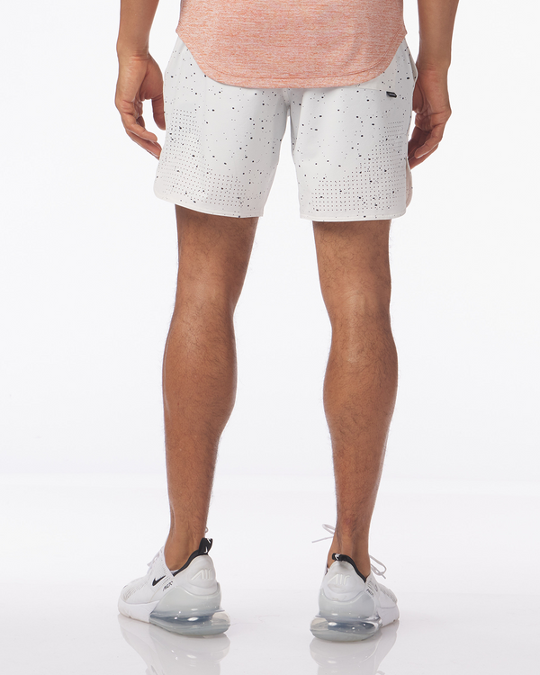 White shorts with black splatter pattern, shown from behind on male model wearing sneakers.