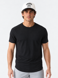 Black crew neck t-shirt with curved hem on male model wearing white cap.