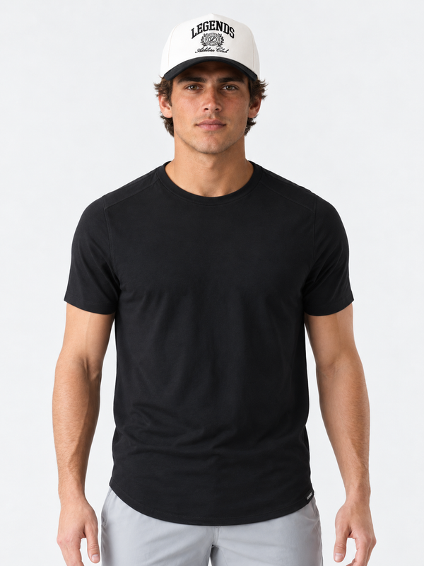 Black crew neck t-shirt with curved hem on male model wearing white cap.