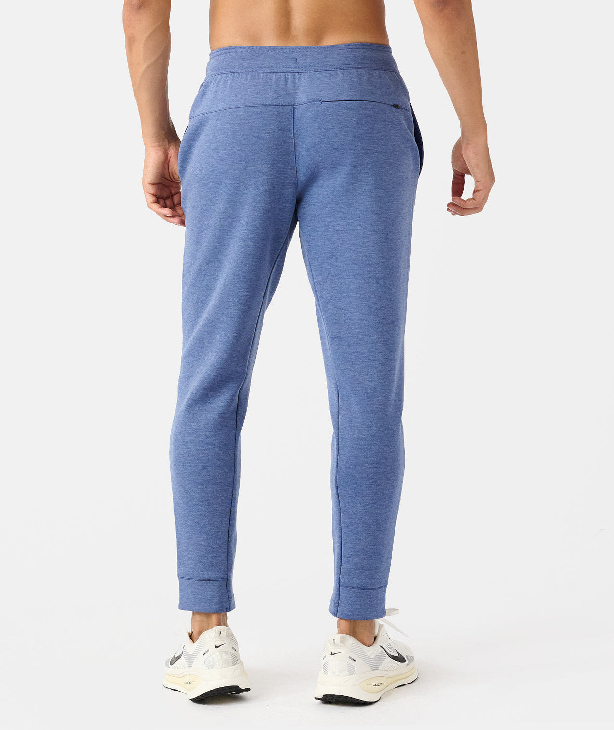 Man wearing blue heather joggers with elastic waistband and cuffed ankles, shown from behind.