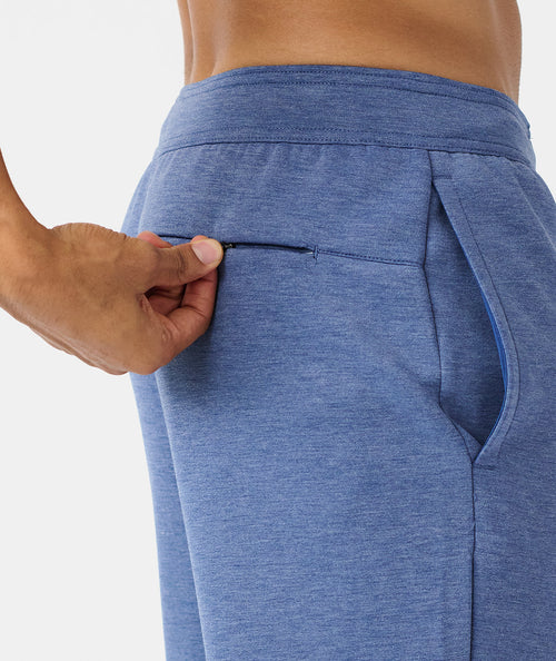 Heather blue jogger pants with elastic waistband and side pockets, shown on model from waist down.