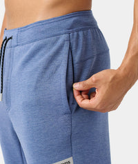 Blue heather joggers with drawstring waist and side pockets, shown from waist down on male model.