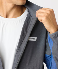 Charcoal full-zip jacket with textured fabric and blue accents, displayed unzipped over white shirt.