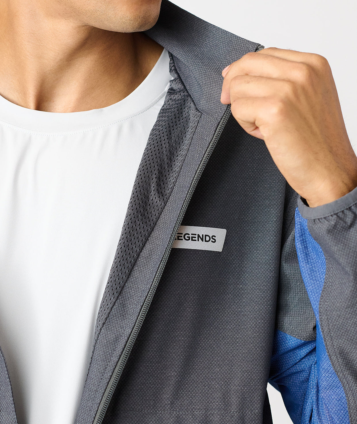 Charcoal full-zip jacket with textured fabric and blue accents, displayed unzipped over white shirt.