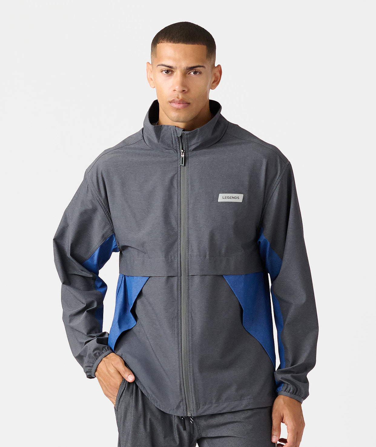 Charcoal and blue full-zip jacket with stand collar and color-block design on sleeves.