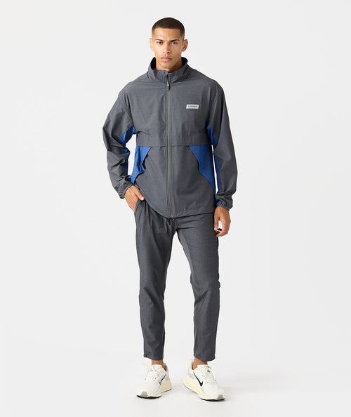 Charcoal full-zip jacket with blue side panels and matching joggers, displayed on male model.