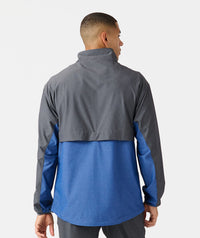 Man wearing charcoal and blue colorblock full-zip jacket with high collar, shown from back.