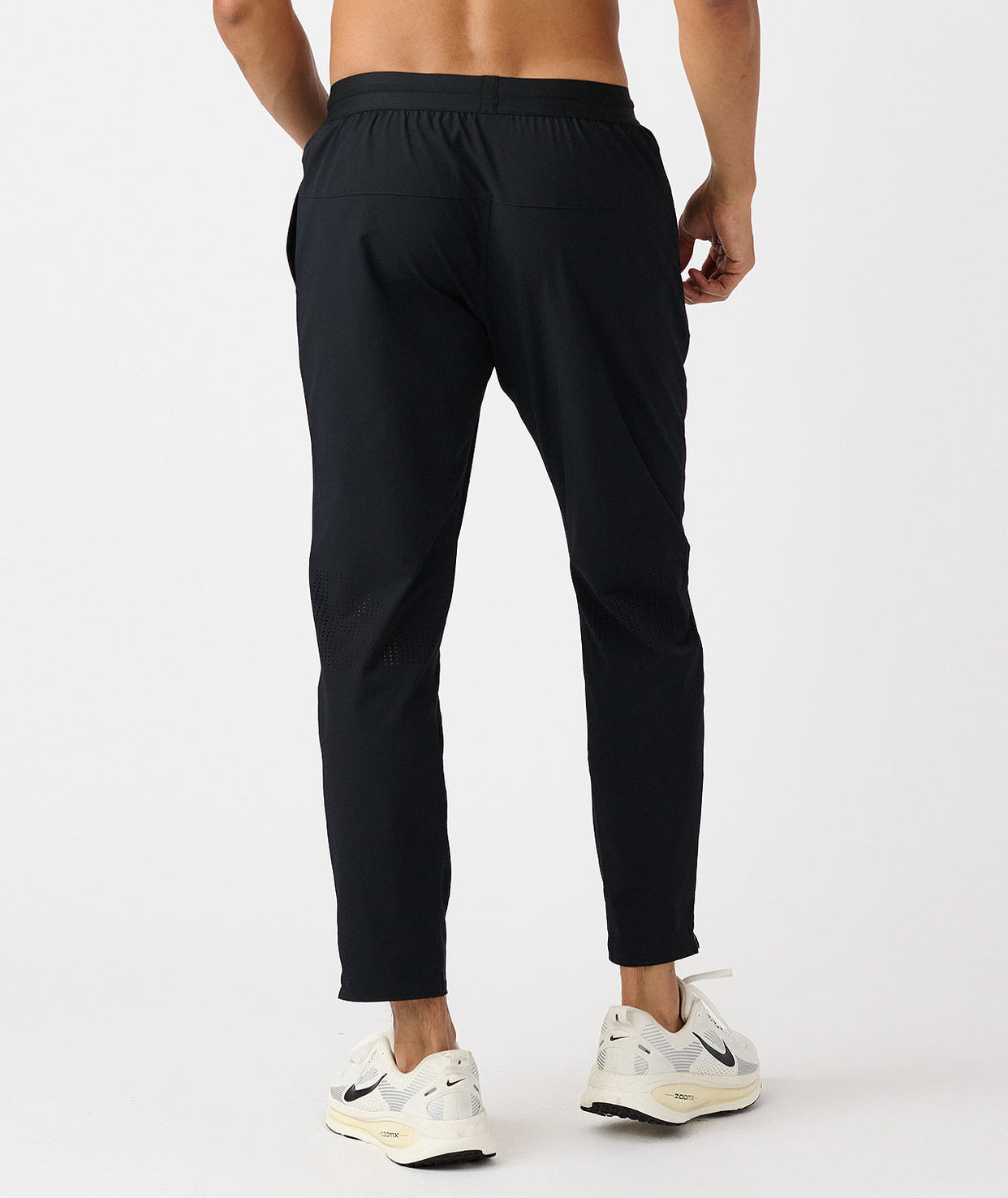 Black tapered athletic pants with elasticated waistband and mesh vents at the calves.