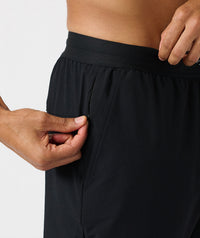 Black pants with elastic waistband and front zipper pocket, worn at hip level.