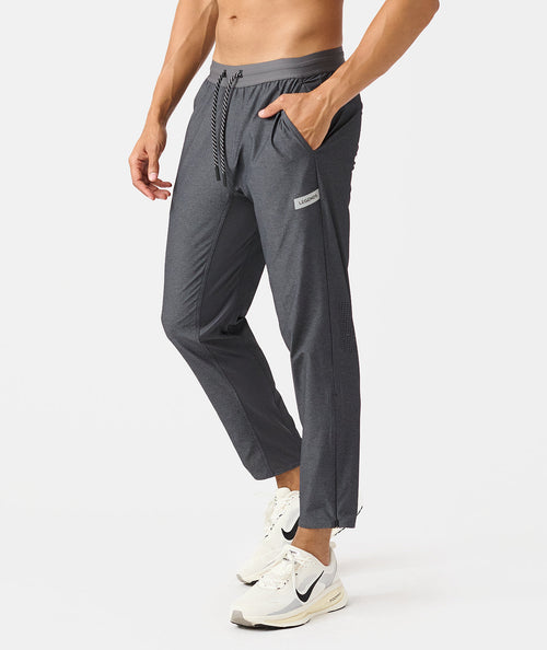 Charcoal gray jogger pants with drawstring waist, side pockets, and mesh panels on the legs.