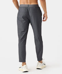 Charcoal gray athletic pant with elastic waistband and textured mesh panels on lower legs, worn by male model.