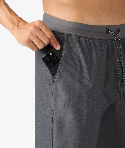Charcoal gray pant with textured fabric and elastic waistband, shown with phone pocket detail and drawstring.