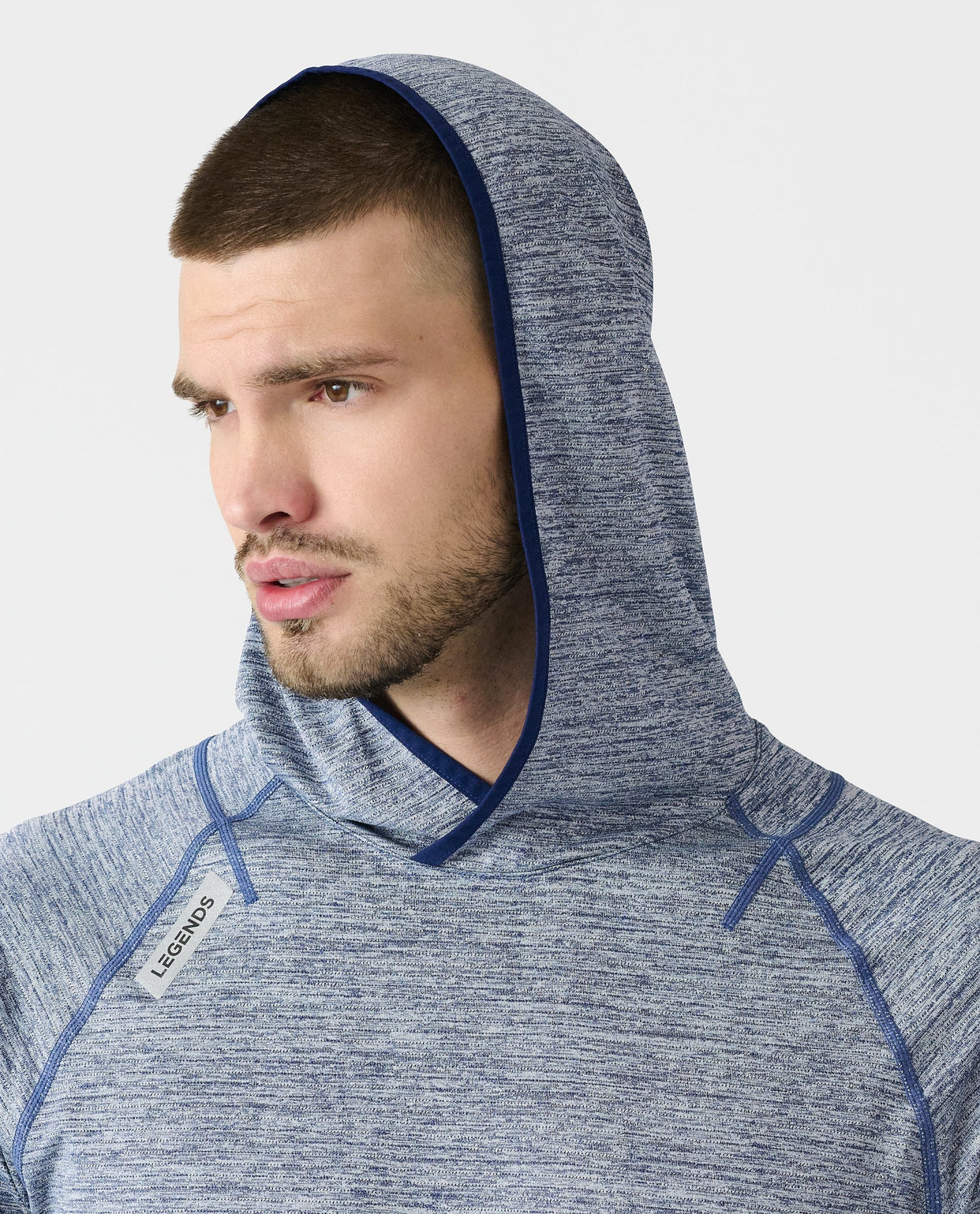 Men's blue heather hooded long-sleeve shirt with navy trim and raglan sleeves worn by model.