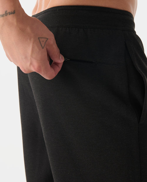 Black heather joggers with elastic waistband and front pocket, shown on model from waist down.