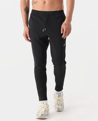 Black heather joggers with drawstring waist and tapered legs, worn with white sneakers.