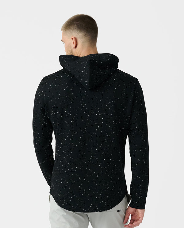 Black quarter-zip hoodie with white speckled pattern, shown from back on model wearing light gray pants.