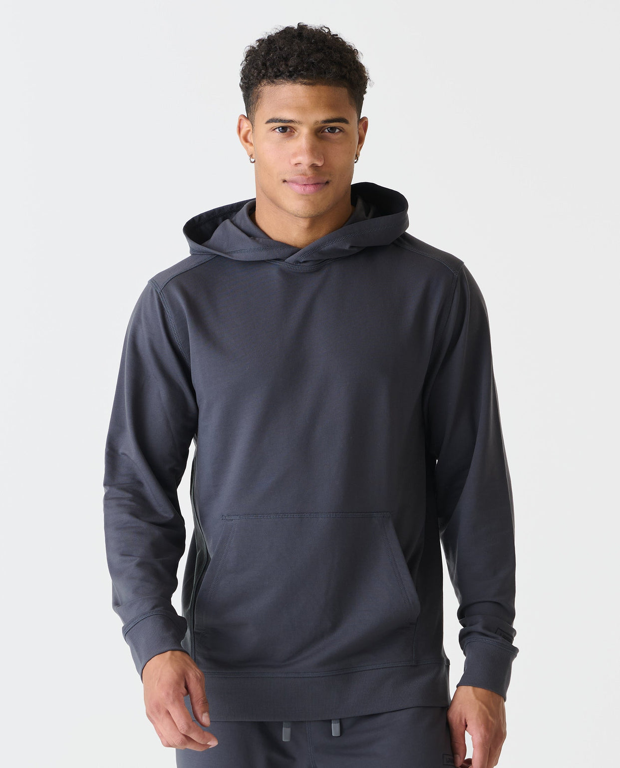 Charcoal gray pullover hoodie with front kangaroo pocket and drawstring hood, worn by model.