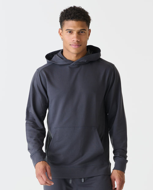 Charcoal gray pullover hoodie with front kangaroo pocket and drawstring hood, worn by model.