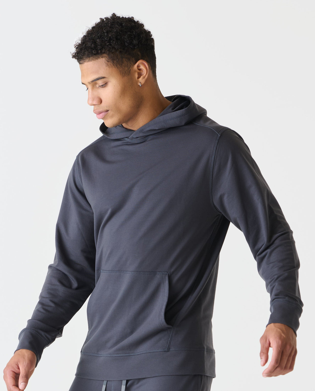 Charcoal gray hoodie with drawstring hood, kangaroo pocket, and ribbed cuffs on a model.