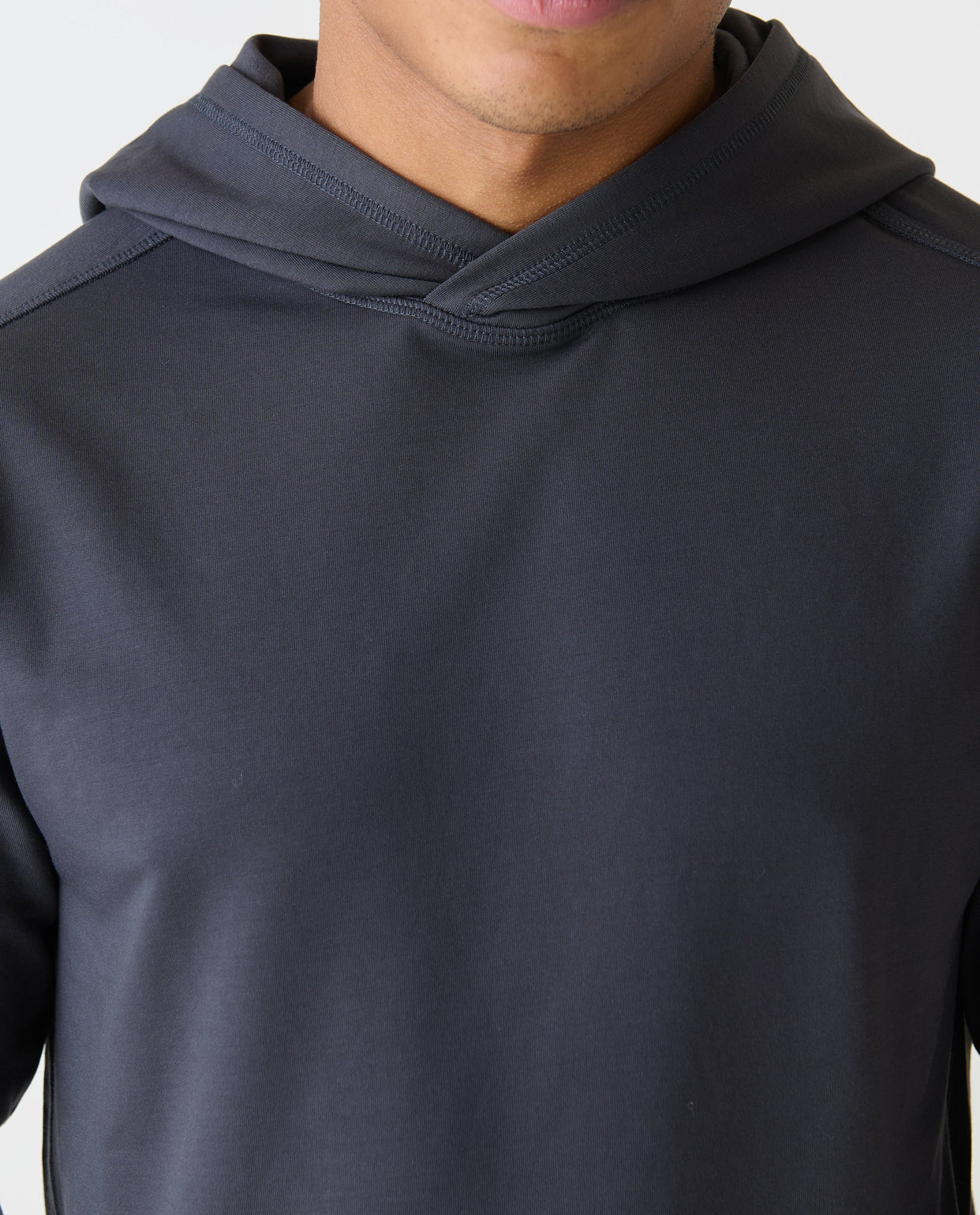 Charcoal gray pullover hoodie with ribbed hood and long sleeves, worn by a man.