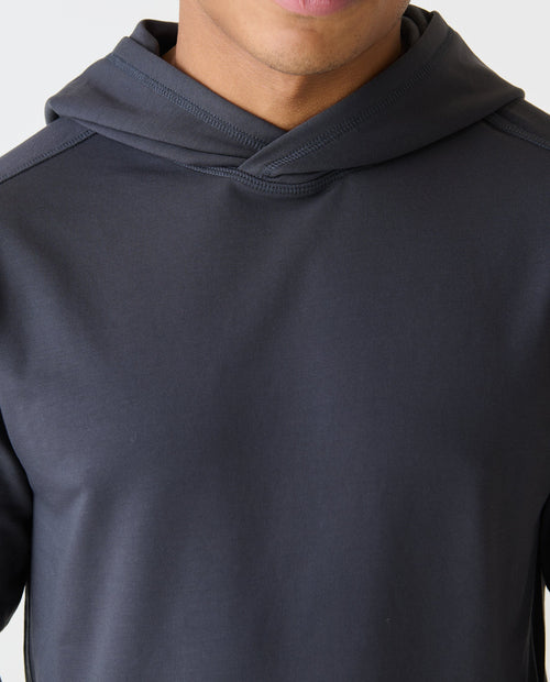 Charcoal gray pullover hoodie with ribbed hood and long sleeves, worn by a man.