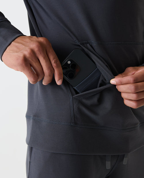 Charcoal gray hoodie with ribbed cuffs and kangaroo pocket, worn open to show interior pocket holding a smartphone.